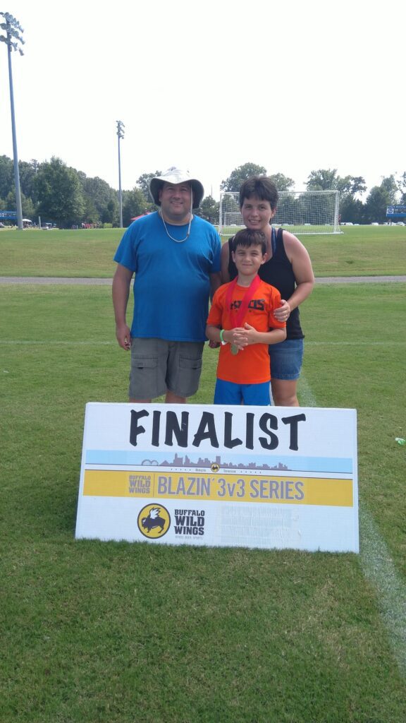 Chris Platania, Team Member of the Year, stands with his family behind a large FINALIST sign.